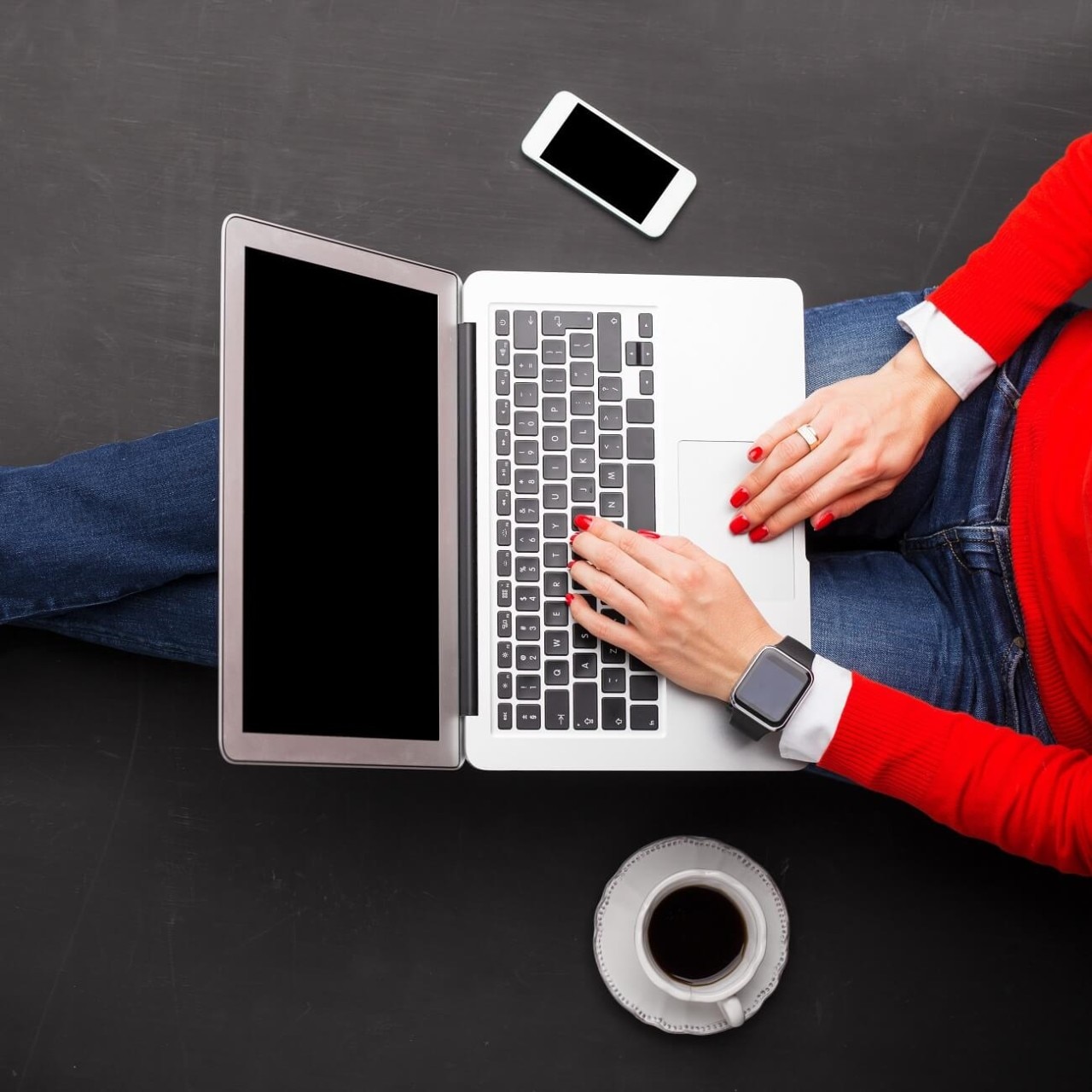 Woman sitting on ground at the office with computer in her lap 